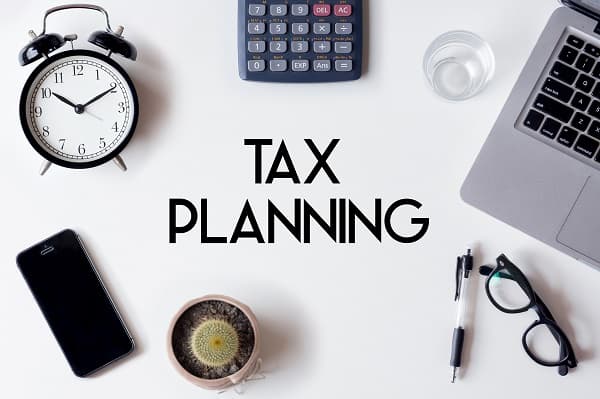 A person reviewing tax documents and using a calculator as part of a financial planning session